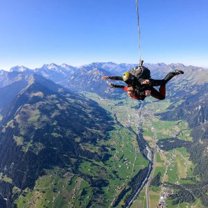 Skydiving over the Swiss Alps with a view of the stunning landscape around Interlaken.