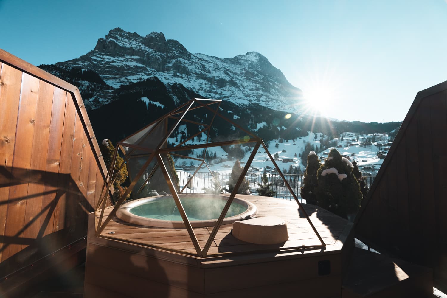 Winter Signature Room at Hotel Glacier Grindelwald with private outdoor whirlpool, boutique alpine hotel luxury, spa retreat, and sunrise over the Eiger