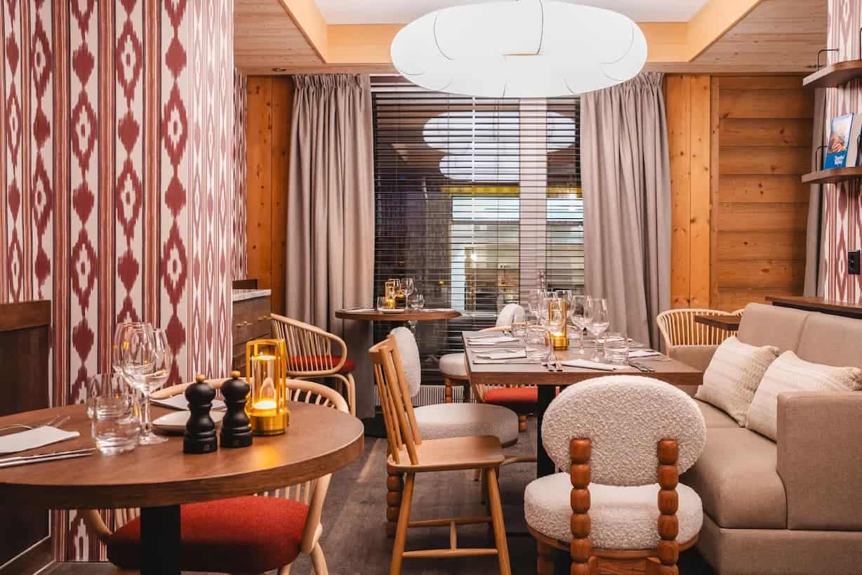 Interior of Braunbär Restaurant in Wengen with soft lighting, alpine design, and books on shelves.